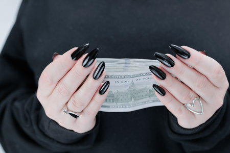 female hands holding American dollar paper billsの写真素材