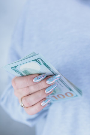 female hands holding American dollar paper billsの写真素材