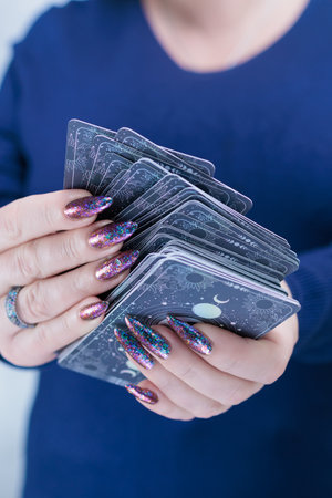 Female hands holding tarot cards for fortune telling and tricksの写真素材