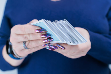 Female hands holding tarot cards for fortune telling and tricks