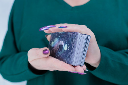 Female hands holding tarot cards for fortune telling and tricksの写真素材