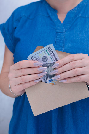 female hands holding American dollar paper billsの写真素材