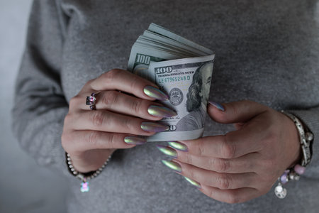 female hands holding American dollar paper billsの写真素材