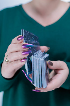 Female hands holding tarot cards for fortune telling and tricks