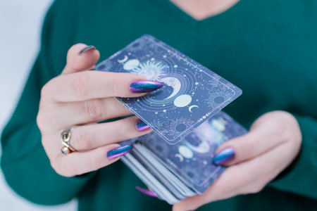 Female hands holding tarot cards for fortune telling and tricks