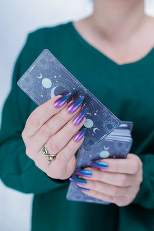 Female hands holding tarot cards for fortune telling and tricks