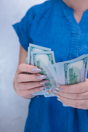 woman's hands holding American dollar paper bills