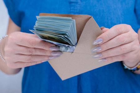 woman's hands holding American dollar paper bills