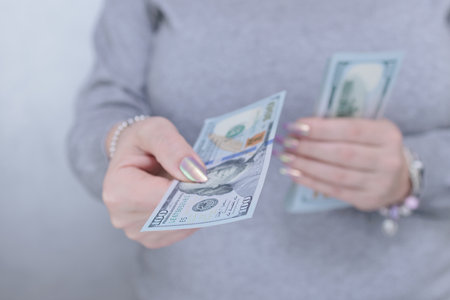 woman's hands holding American dollar paper billsの写真素材