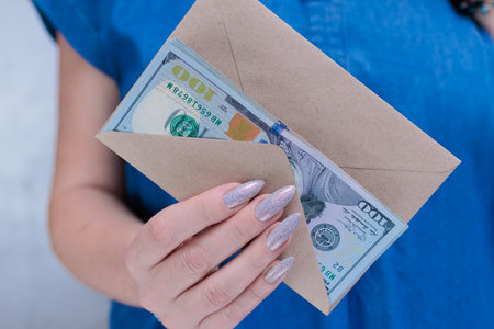 woman's hands holding American dollar paper billsの写真素材