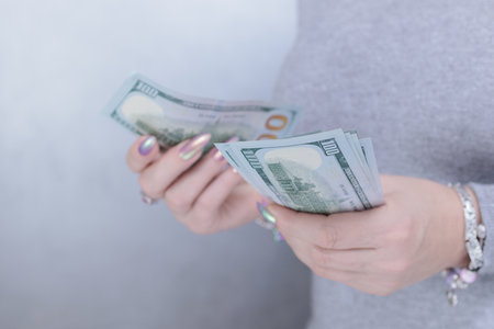woman's hands holding American dollar paper billsの写真素材