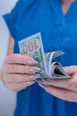 woman's hands holding American dollar paper bills