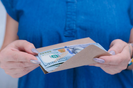 woman's hands holding American dollar paper billsの写真素材