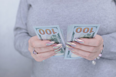 woman's hands holding American dollar paper bills