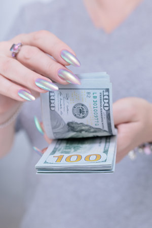 woman's hands holding American dollar paper bills