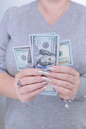 woman's hands holding American dollar paper bills