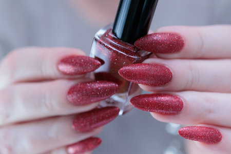 Female hands with long nails and dark red nail polish