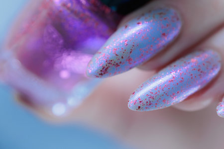 Woman hand with long nails manicure and light blue and pink nail polishの写真素材