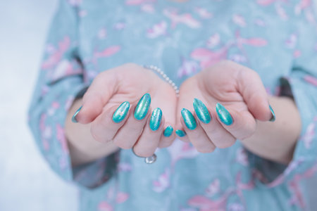 Female hand with long nails and neon light green manicureの写真素材
