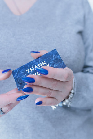 Female hands hold a picture with the inscription Thank you