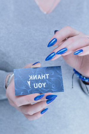 Female hands hold a picture with the inscription Thank you