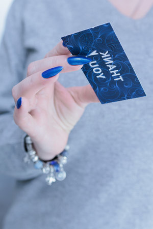 Female hands hold a picture with the inscription Thank you
