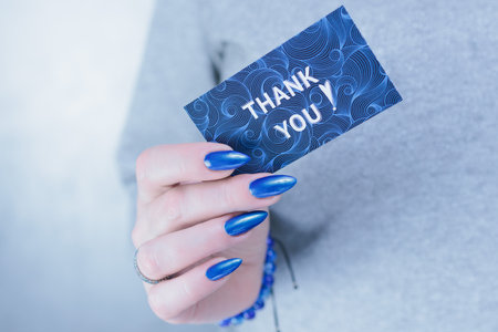 Female hands hold a picture with the inscription Thank you