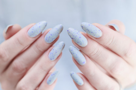 woman hands with long nails light gray blue lilac manicureの写真素材