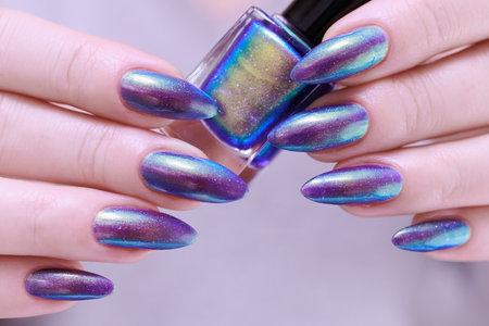beautiful female hand with long nails, purple and blue manicure
