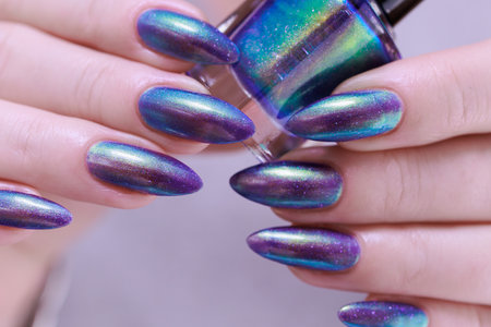 beautiful female hand with long nails, purple and blue manicureの写真素材