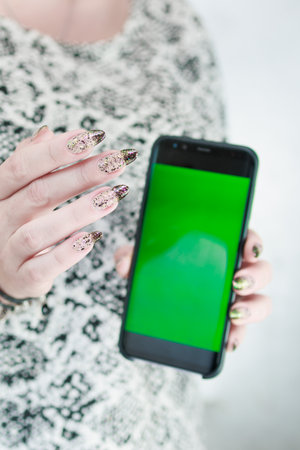 Woman's hands holding a large smartphoneの写真素材