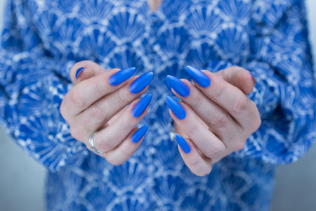 Woman's beautiful hand with long nails and bright blue manicureの写真素材