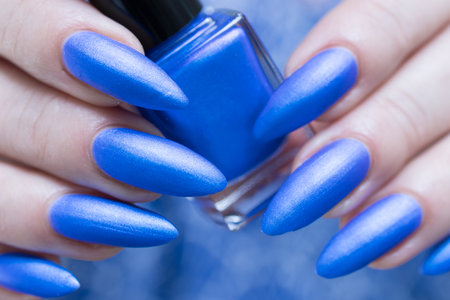 Woman's hand with long nails and bright blue manicureの写真素材