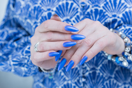 Woman's beautiful hand with long nails and bright blue manicureの写真素材