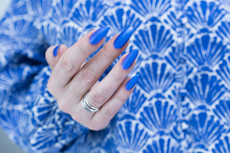 Woman's beautiful hand with long nails and bright blue manicureの写真素材