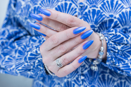 Woman's beautiful hand with long nails and bright blue manicureの写真素材