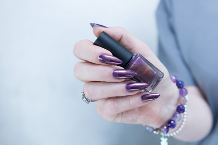 Beautiful woman's hand with long nails and multicolored nail polish, blue and brown