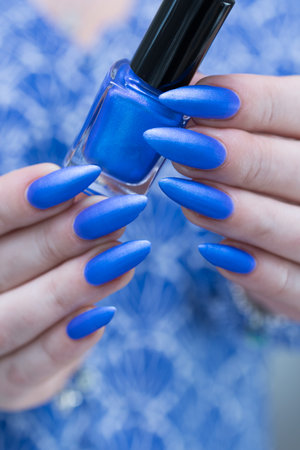 Woman's hand with long nails and bright blue manicureの写真素材
