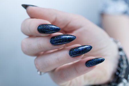 Woman's hand with long nails and blue manicureの写真素材