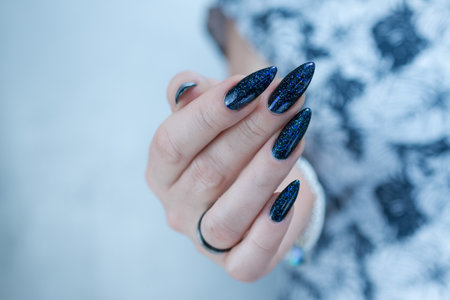Woman's hand with long nails black and dark blue manicureの写真素材