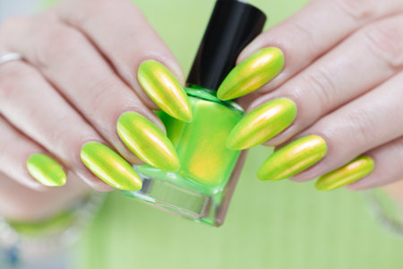 Female hand with long nails and neon yellow green manicureの写真素材
