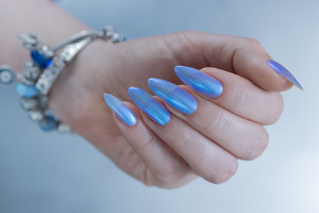 Woman's beautiful hand with long nails and light baby blue manicureの写真素材