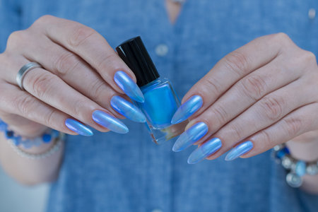 Woman's beautiful hand with long nails and bright blue manicureの写真素材