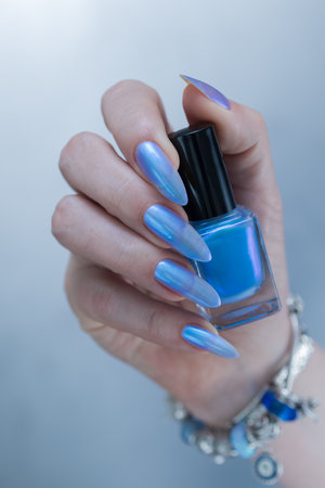 Woman's beautiful hand with long nails and bright blue manicureの写真素材