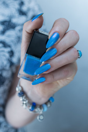 Woman's beautiful hand with long nails and bright blue manicureの写真素材