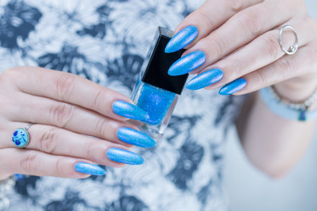 Woman's beautiful hand with long nails and bright blue manicureの写真素材