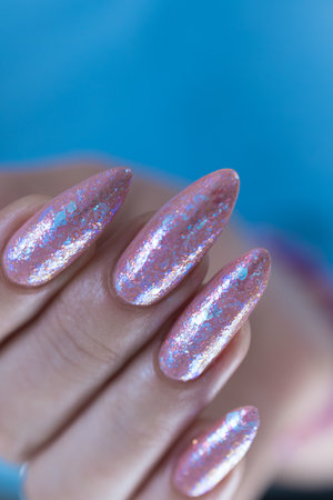 Female hands with long nails and a light pink color nail polishの写真素材