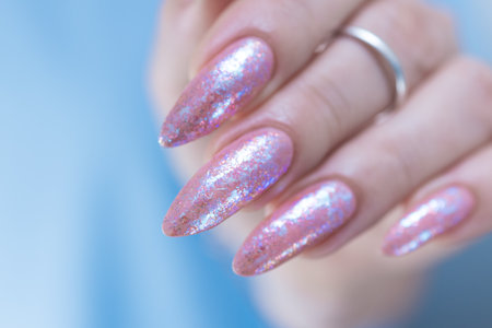 Female hands with long nails and a light pink color nail polishの写真素材
