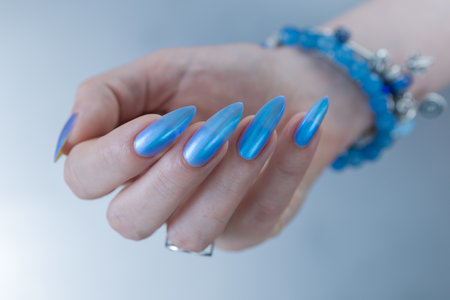Woman's beautiful hand with long nails and bright blue manicureの写真素材