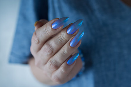 Woman's beautiful hand with long nails and bright blue manicureの写真素材